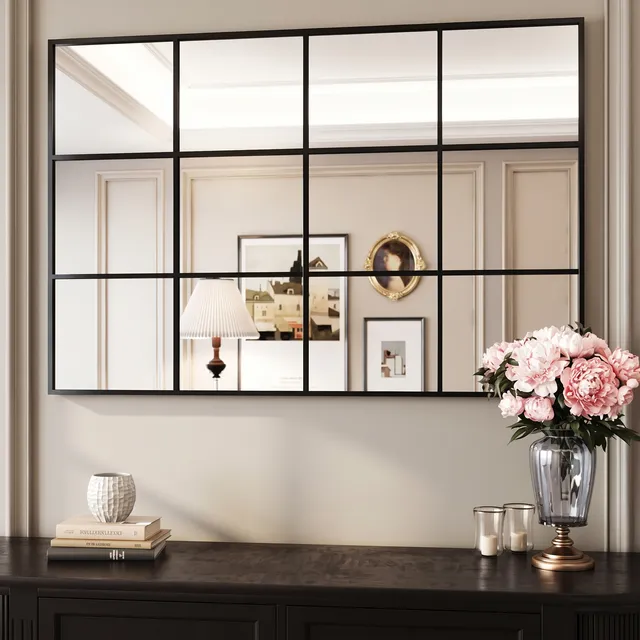 Miroir Fenêtre cadre métal noir au-dessus d’un buffet avec pivoines