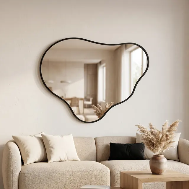 Miroir Lagon cadre métal noir au-dessus d’un canapé bouclé