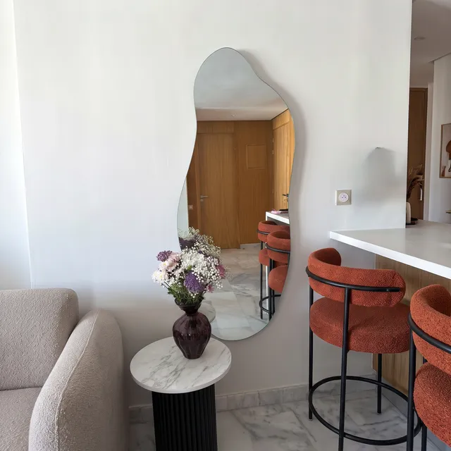 Miroir Nuage organique pleine hauteur dans un salon avec tabourets orange