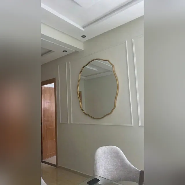 Miroir Vague cadre doré dans une entrée avec moulures classiques