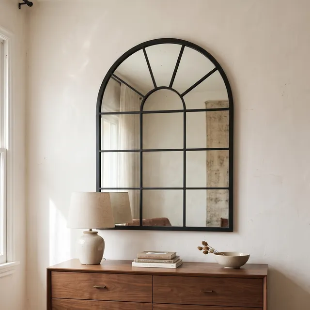 Miroir Verrière Arche cadre métal noir au-dessus d’une commode en noyer